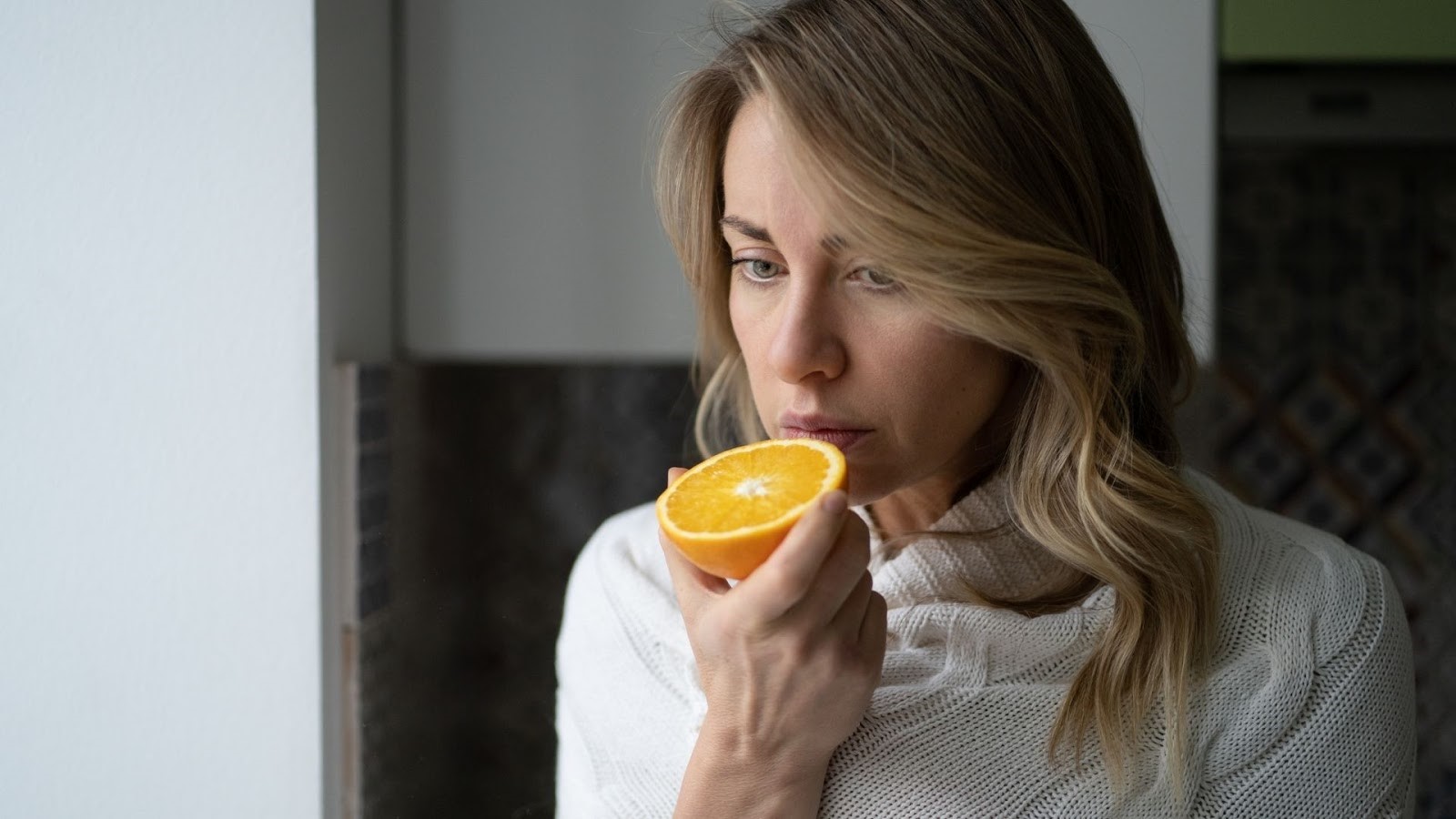 Woman trying to smell an orange