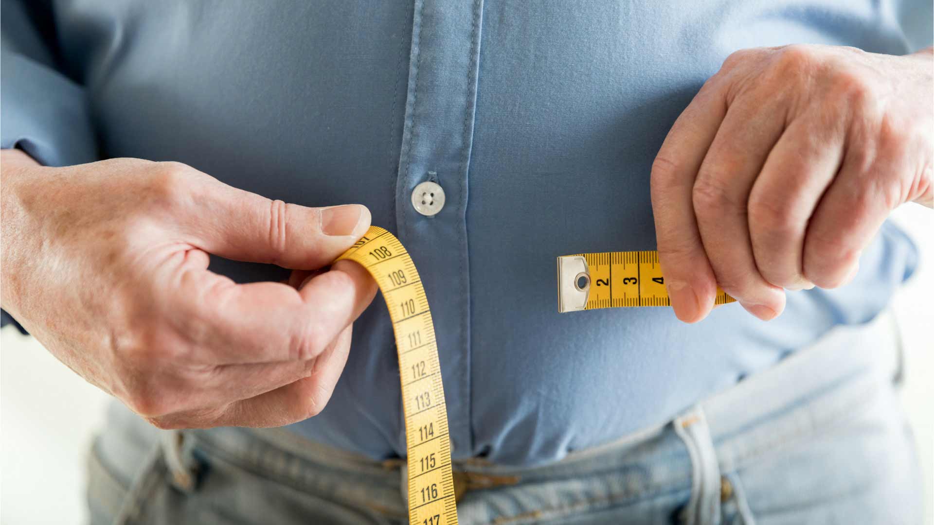man measuring his waist