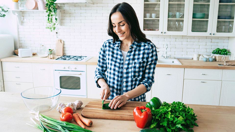 woman cutting vegetables in kitchen