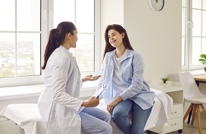 Doctor holding report file with appointment and giving recommendations her woman patient in clinic